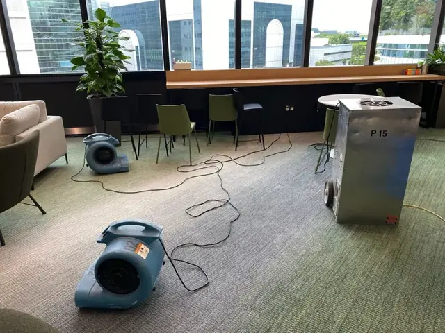 Air movers and a dehumidifier drying an office floor in Columbia, MD