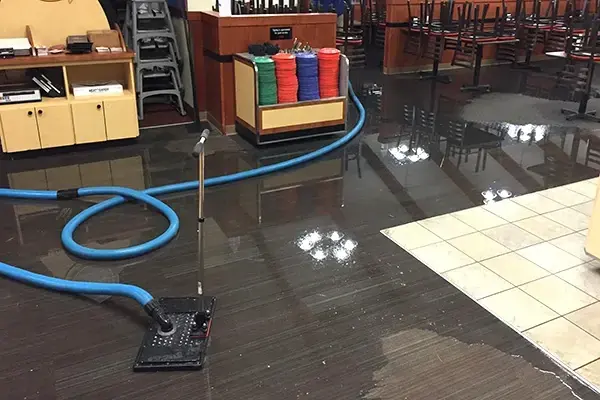 Extraction wand pulling standing water off a flooded floor in Columbia, MD